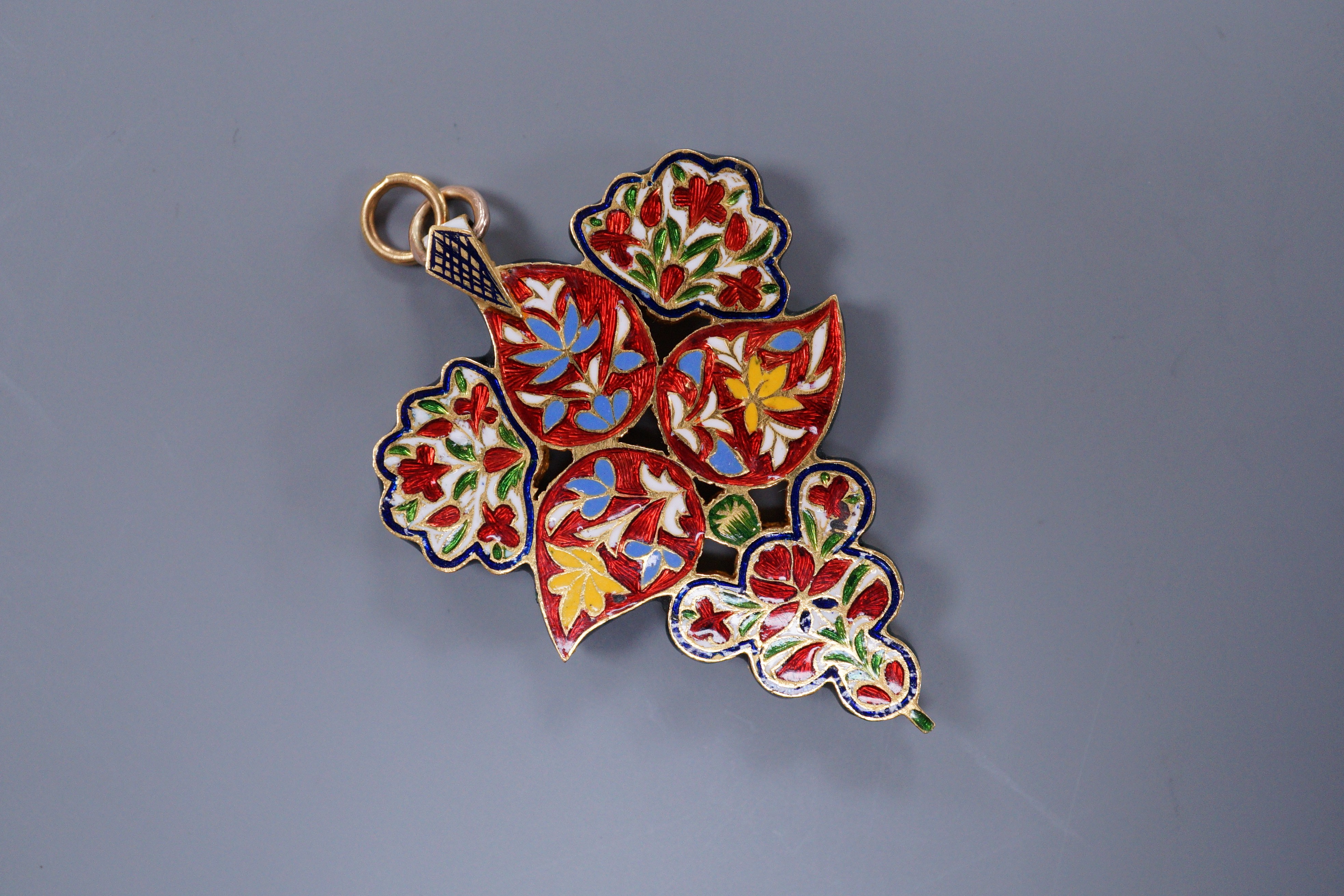 An Indian gold overlay, enamel and rose diamond foliate design pendant, 5cm, gross 15.2 grams